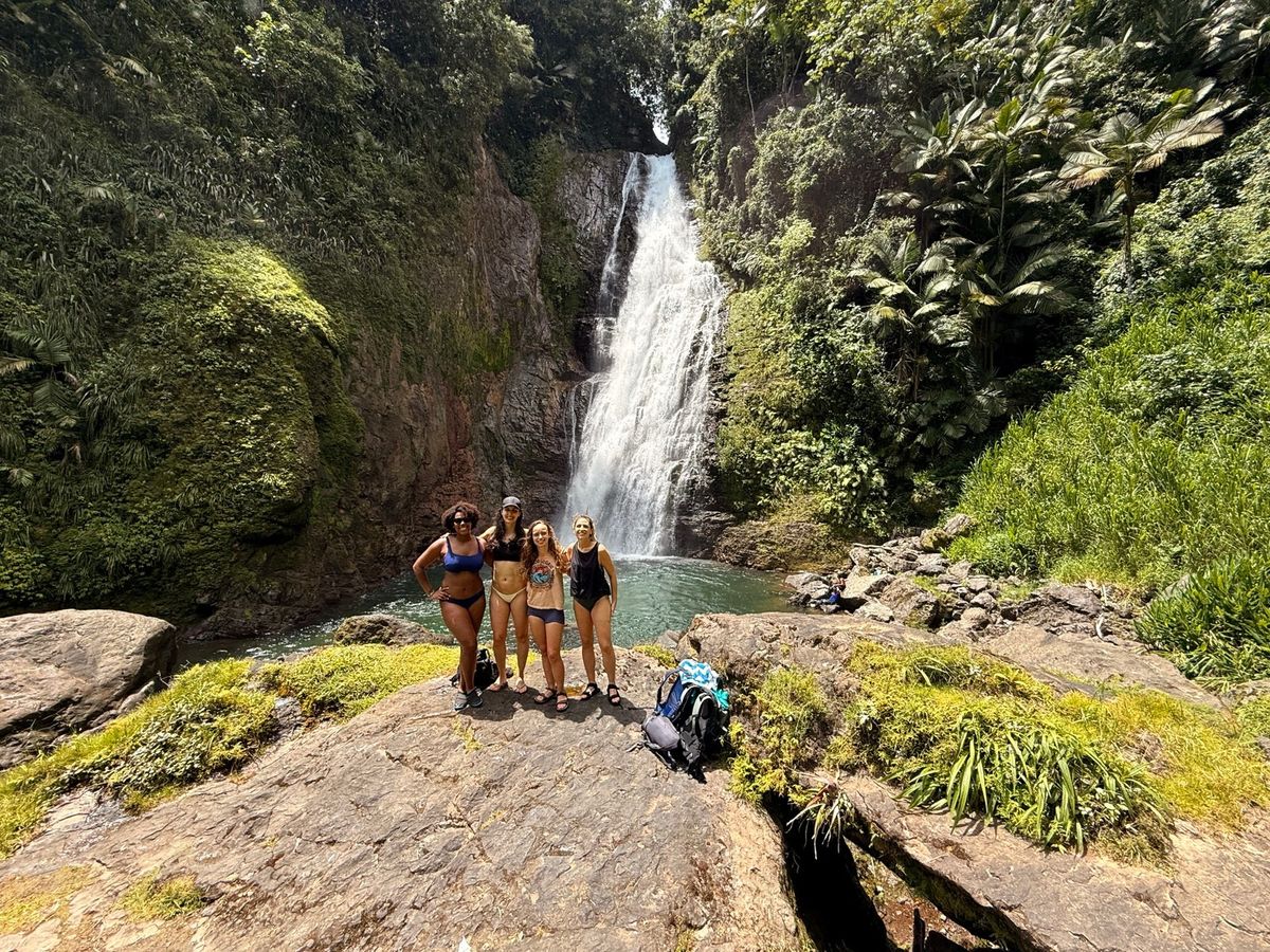 Viajeras al pie de una cascada en la montaña