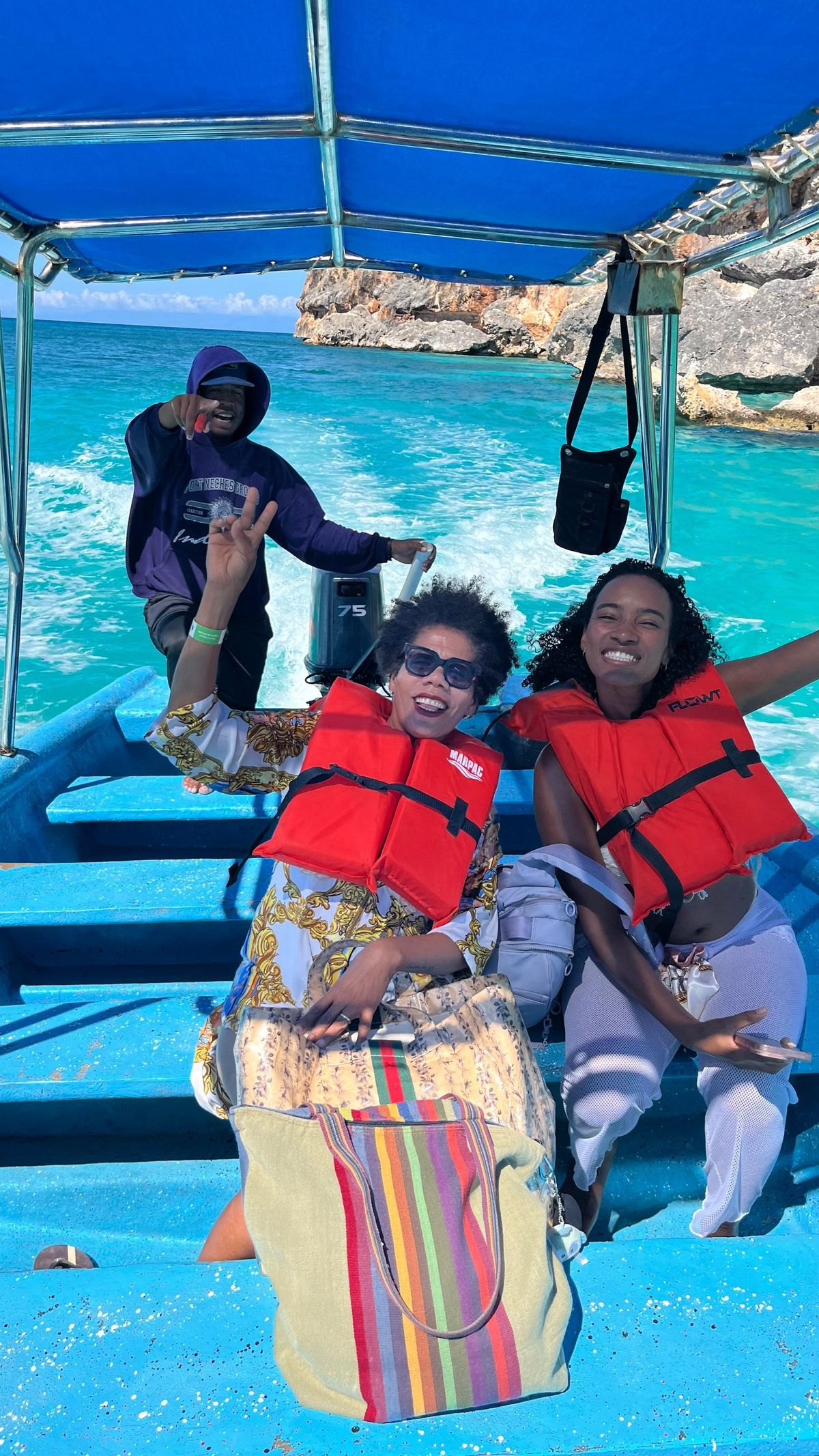 Dos viajeras con chaleco salvavidas ríen en un bote sobre agua turquesa
